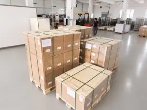 ** Palletized residential ESS cartons stretch-wrapped and strapped on wooden pallets in the Weltrus factory - **Image Name:** residential-ess-factory-packing-shipping-cover-4-3-1200px.jpg - **Aspect Ratio:** 4:3 - **Max Pixels:** 1200px (longest side)
