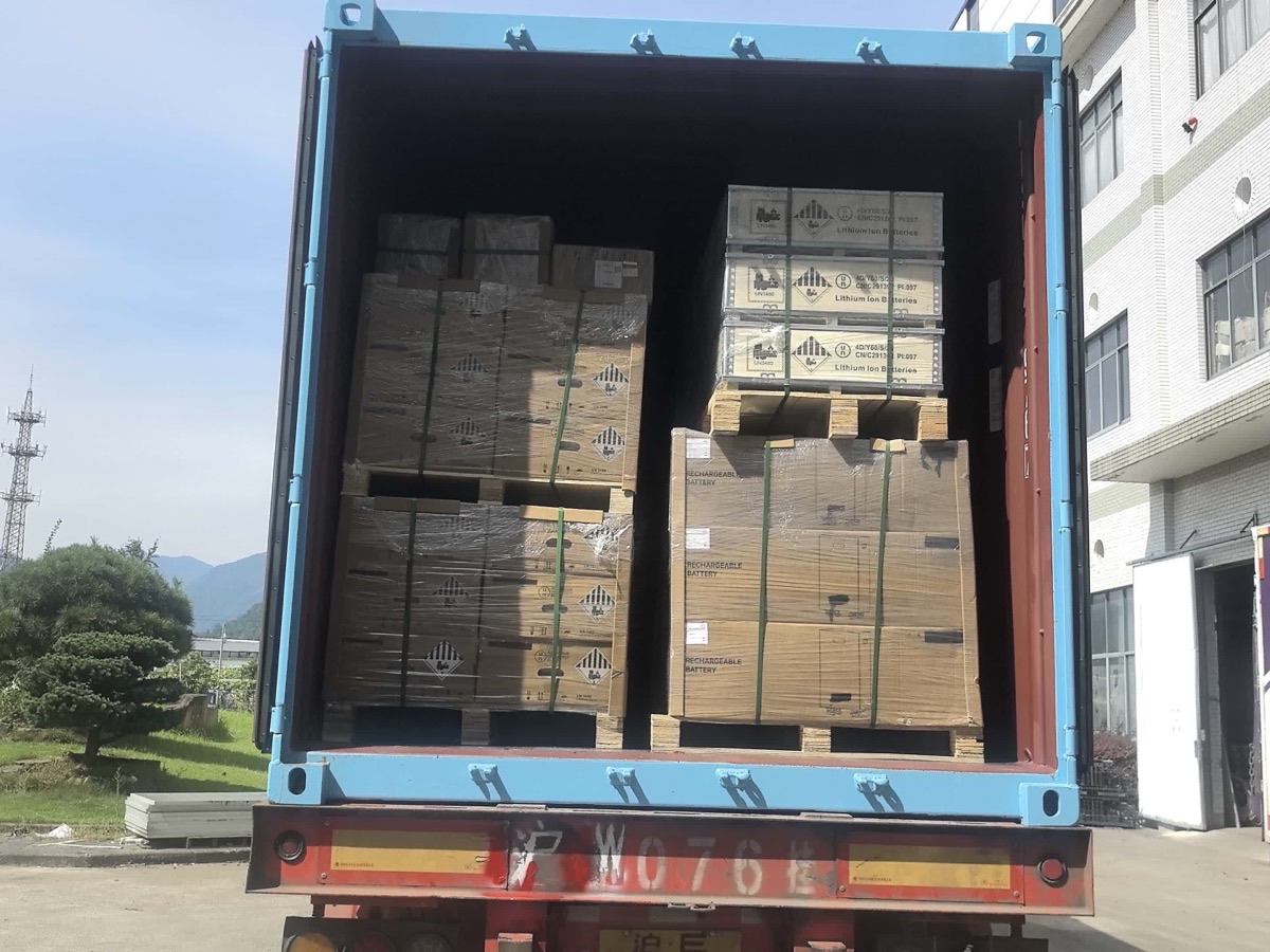 ** Open container at a Weltrus China factory loaded with lithium-ion battery crates and marked cartons
