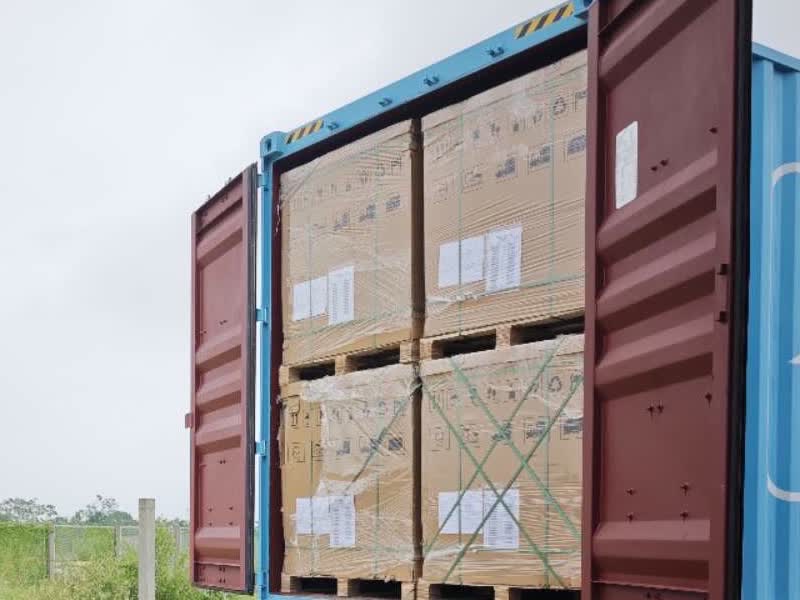 Open shipping container in Vietnam with palletized cartons and packing lists ready to unload