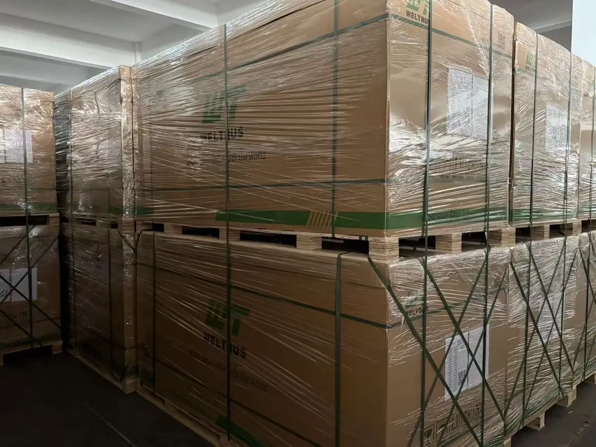 ** Double-stacked Weltrus solar module pallets staged in the factory warehouse for container loading
