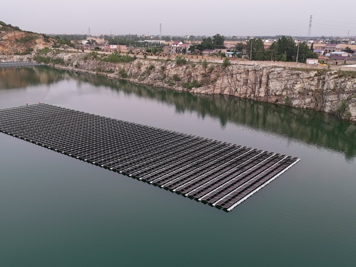 Floating solar array on a rock-sided reservoir, photographed from above